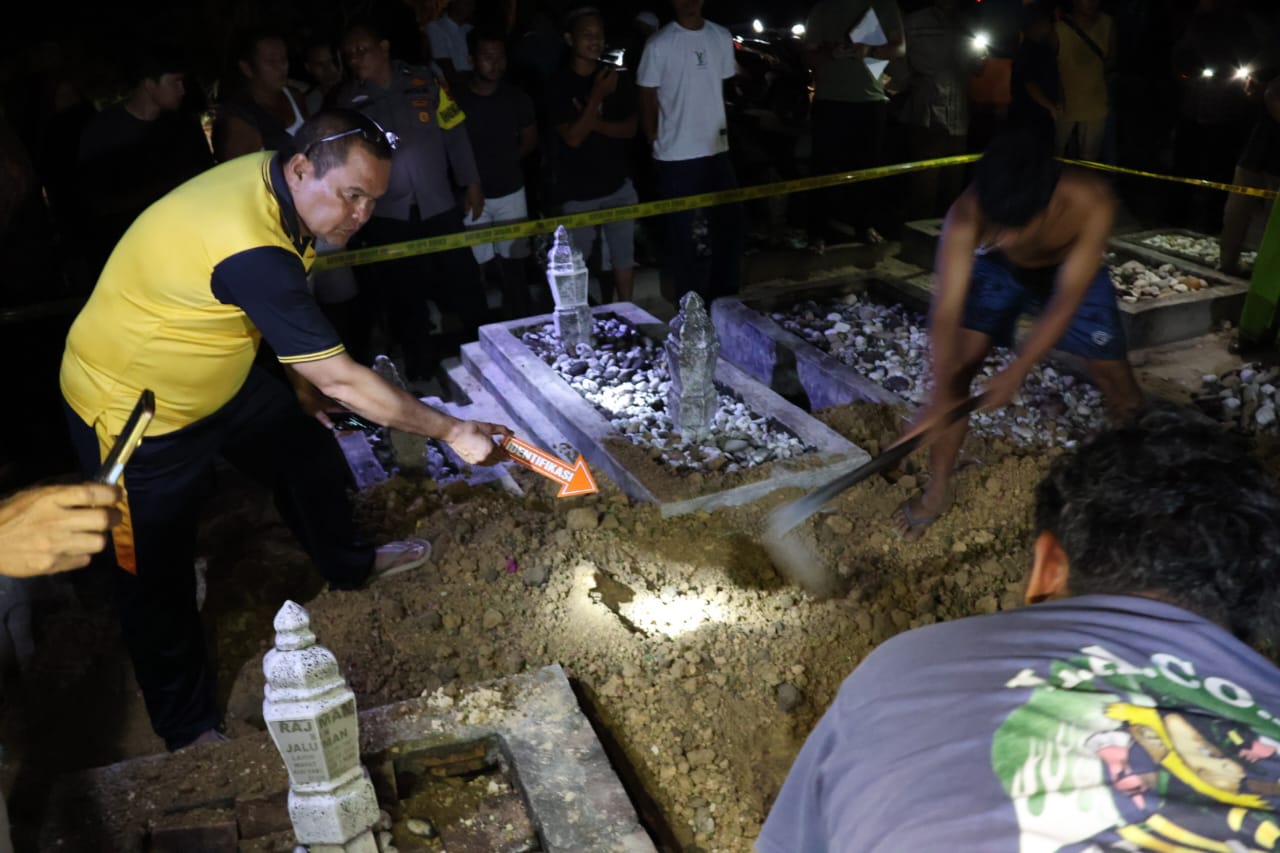 BONGKAR: Personel Polsek Kampung Rakyat, Labusel dan warga saat membongkar makam IN (14) yang bunuh diri. (Dok: istimewa for Sumut Pos)