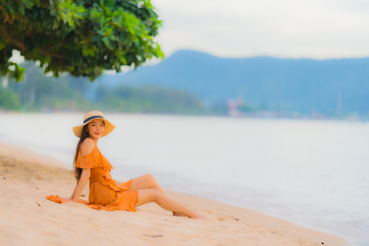 ilustrasi: Seorang wanita menikmati keindahan pantai. (Freepik)