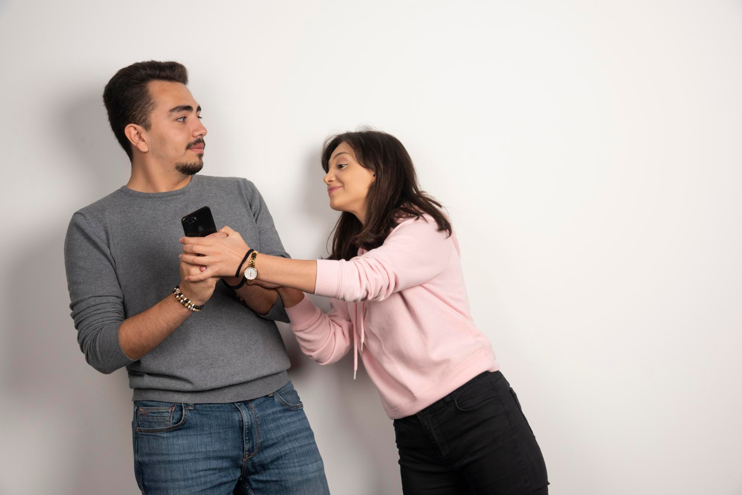 ilustrasi: Seorang wanita berusaha mengambil ponsel dari teman prianya. (Freepik)