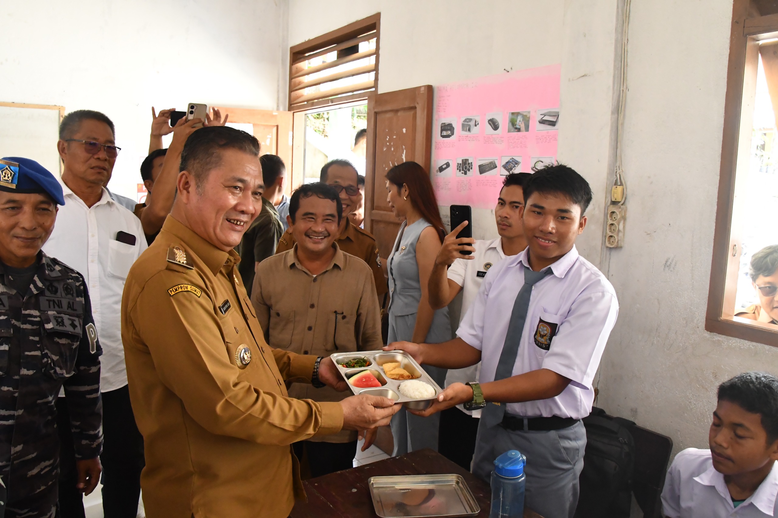 Bagikan : Bupati Nias Selatan, Sokhiatulo Laia saat pembagian makanan bergizi gratis kepada siswa SMK Swasta BNKP Teluk Dalam. (EURISMAN/SUMUT POS)