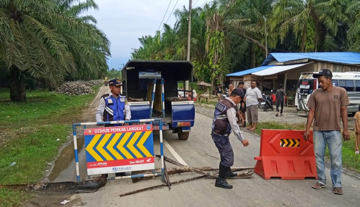 Petugas saat pasang rambu lalu lintas dan penerangan di Jalan Lintas Batangserangan-Kwalasawit, Dusun Titi Kurus, Desa Karya Jadi, Batangserangan. (Istimewa/Sumut Pos)