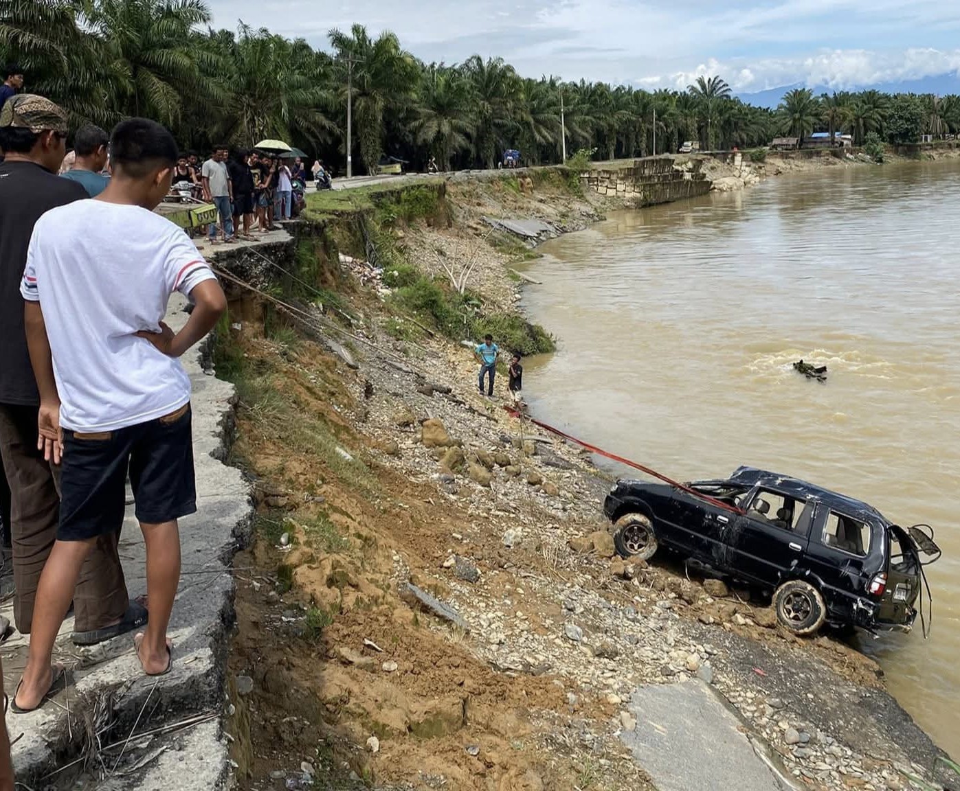 DIEVAKUASI: Mobil wisawatan asal Karo yang  nyemplung di aliran Sungai Batangserangan saat dilakukan evakuasi. (Istimewa/Sumut Pos)