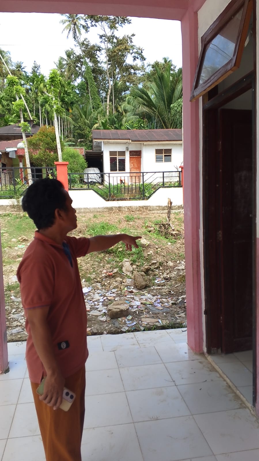 RUSAK: Ketua Komite SD Negeri Laowi saat menunjukkan pintu yang rusak. (Dok: istimewa/Sumut Pos)