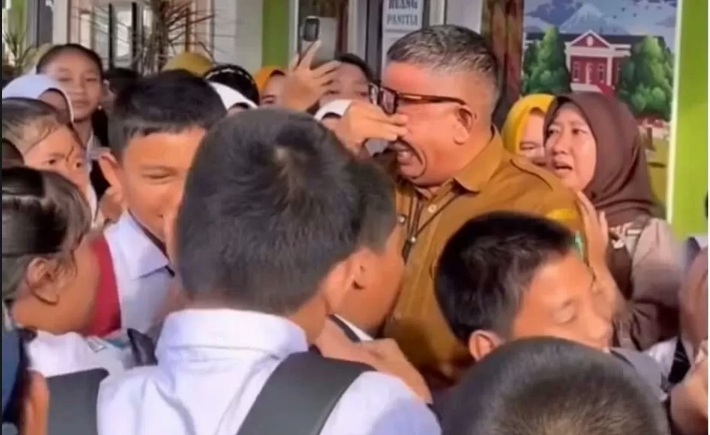 Viral Kepala SMP Negeri 1 Prabumulih saat menghapus air matanya saat bersalaman dengan siswa. (Dok: tangkapan layar)