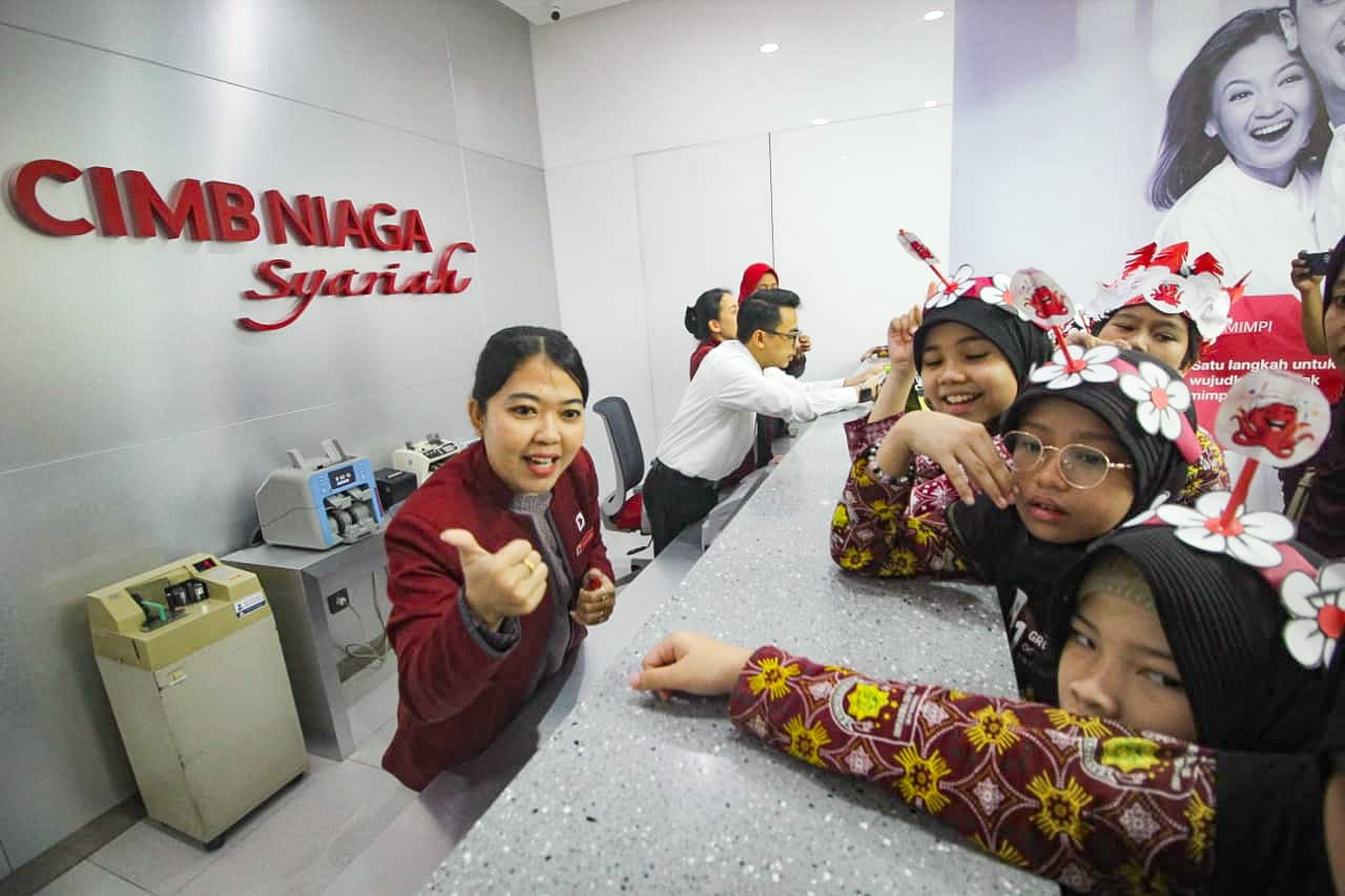 Seorang Teller di Kantor Cabang CIMB Niaga Syariah Medan memberikan pemahaman mengenai pengenalan uang kepada pelajar Sekolah Dasar, Sabtu (20/9/2025). (Triadi Wibowo)