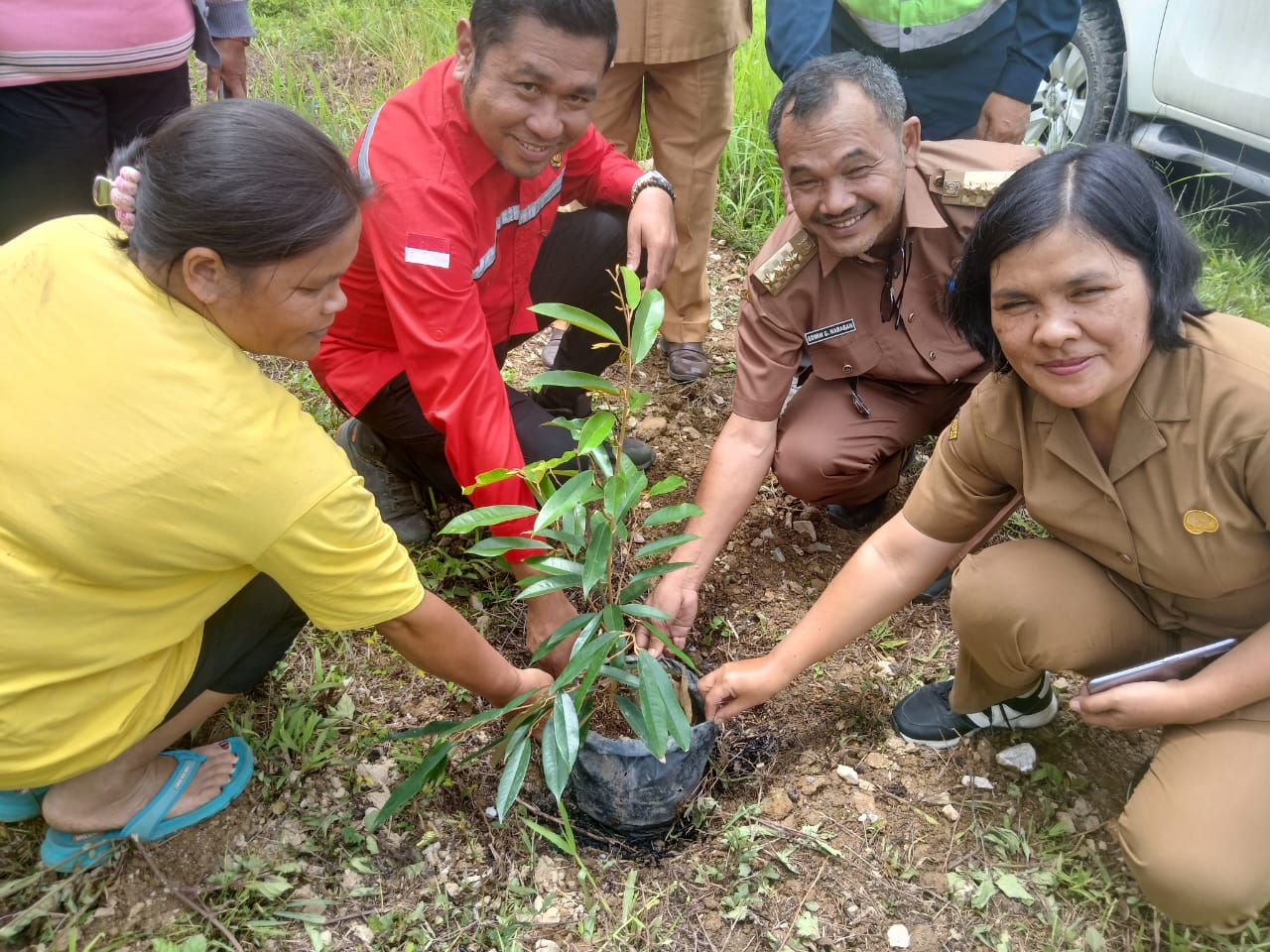 Camat Silima Pungga-Pungga, Edwin Nababan dan KTT PT DPM, Rinto menanam bibit durian yang diberikan kepada petani.