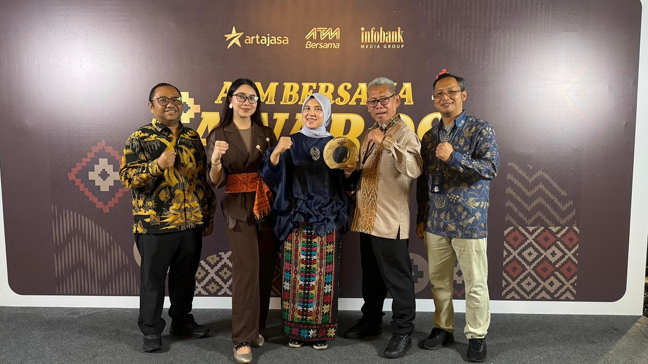 PAMERKAN: Direktur Keuangan & Teknologi Informasi PT Bank Sumut Arieta Aryanti, saat memamerkan penghargaan yang diraih pada ATM Bersama Awards 2025 di Manado, Sulawesi Utara, Jumat (19/9).