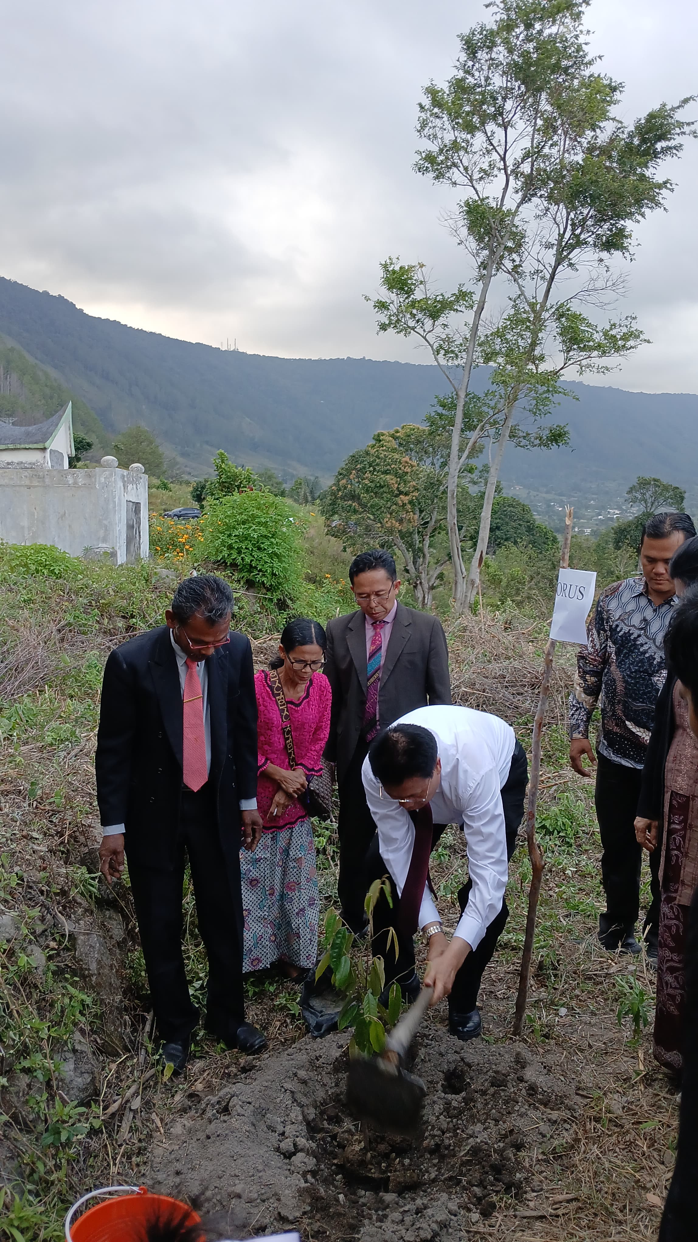 TANAMAN: Ephorus HKBP Pendeta Dr Viktor Tinambunan melakukan penanaman pohon dikawasan Danau Toba Silalahi bantuan YPDK dan APUK peringatan Minggu Ekologi HKBP, Sabtu (27/9/2025). (Dok: istimewa)
