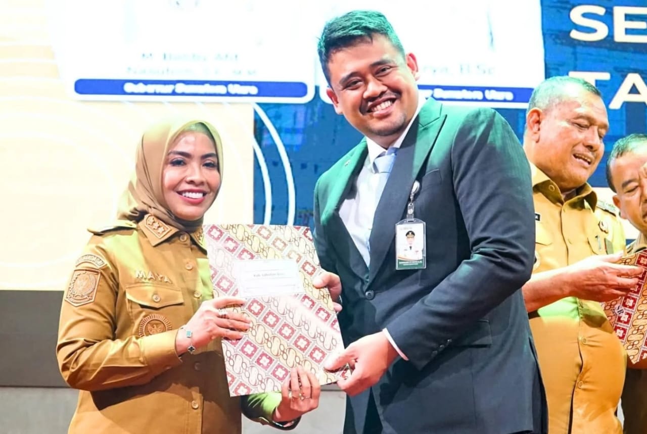 Bupati Labuhanbatu Maya Hasmita menerima penghargaan Universal Health Coverage (UHC) dari Gubsu M Bobby Nasution (ISTIMEWA/SUMUT POS