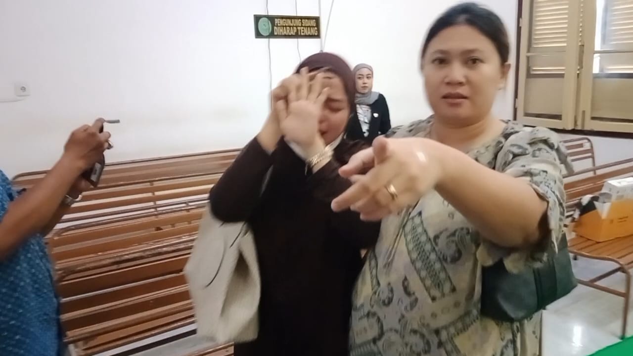 Wanita yang melakukan perampasan handphone wartawan (kanan), saat peliputan sidang korupsi di Pengadilan Tipikor Medan, Senin (29/9).