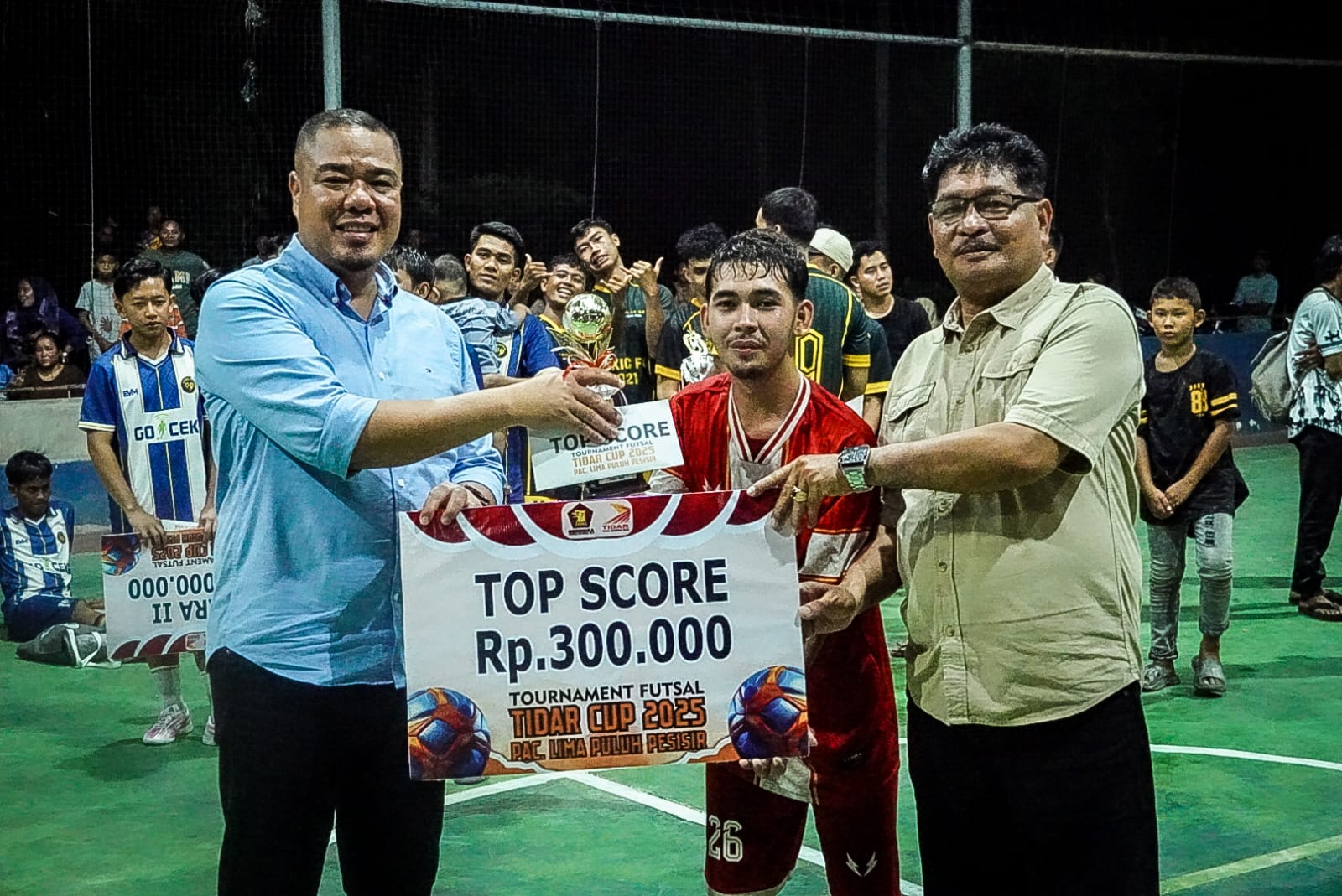 Wakil Bupati Batu Bara, Syafrizal, SE, M.AP didampingi  Plt. Kadisporabudpar  Widaruna saat serahkan troppy Juara Turnamen Futsal Tidar Cup PAC Lima Puluh Pesisir, Selasa (30/9/2025) malam.