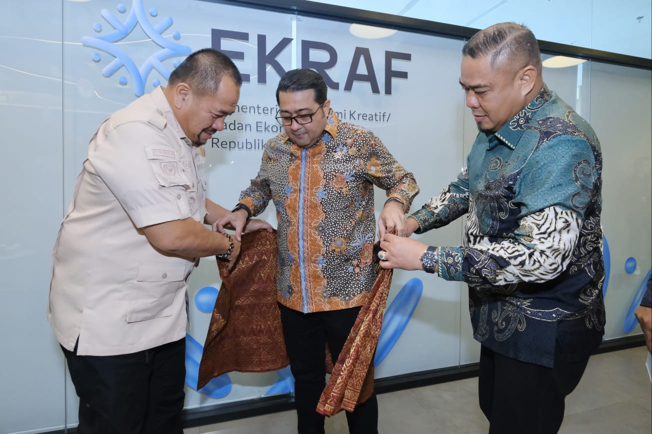 Bupati Batubara  H. Baharuddin Siagian, S.H., M.Si., bersama Wakil Bupati Syafrizal, SE, M.AP saat menyematkan cenderama berupa songket   Batubara kepada  Menteri Ekonomi Kreatif Republik Indonesia.
