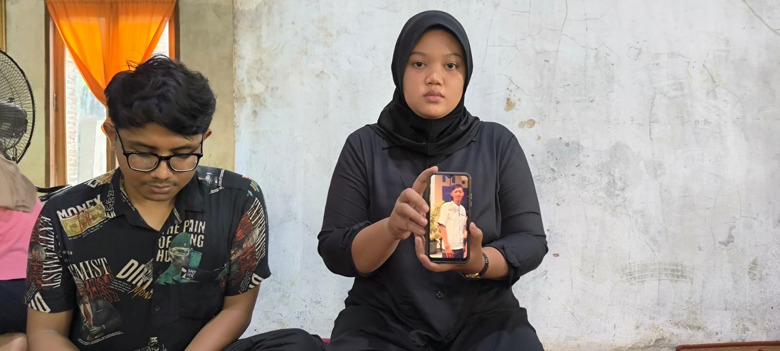 Adik Argo, Ega Prasetya (kanan) saat menunjukkan foto korban semasa hidup di rumah, Desa Karang Rejo, Kecamatan Stabat, Langkat. (Teddy Akbari/Sumut Pos)