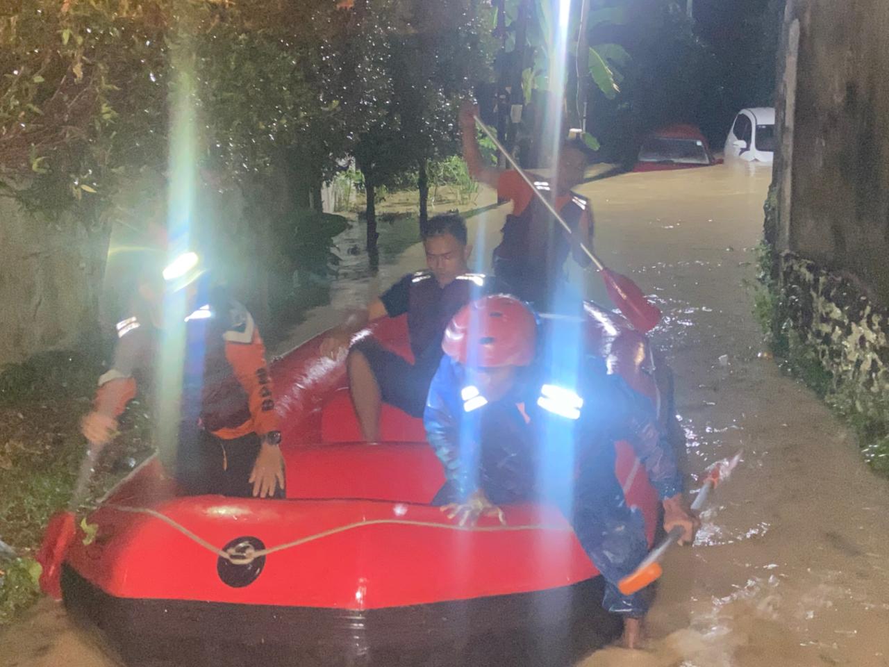 EVAKUASI: Petugas BPBD Kota Medan melakukan evakuasi terhadap warga yang terjebak banjir, Sabtu (11/10). (ISTIMEWA/SUMUT POS)