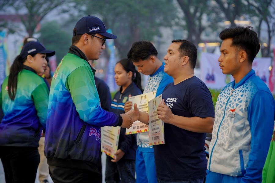 Wali Kota Medan Rico Waas ketika secara simbolis menyerahkan tali asih peraih medali PON 2024 pada pembukaan Porkot Medan 2025 di Lapangan Merdeka, Sabtu (11/10/2025). (Dok Pribadi)