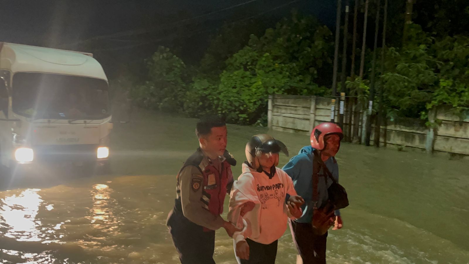 Polisi saat membantu warga menghadapi banjir, di Jalan Sisingamangaraja, tepatnya di depan Restoran Kembang dan Perumahan Taman Rivera, Minggu (12/10) dini hari. (Sumut Pos/Dokumen Pribadi)