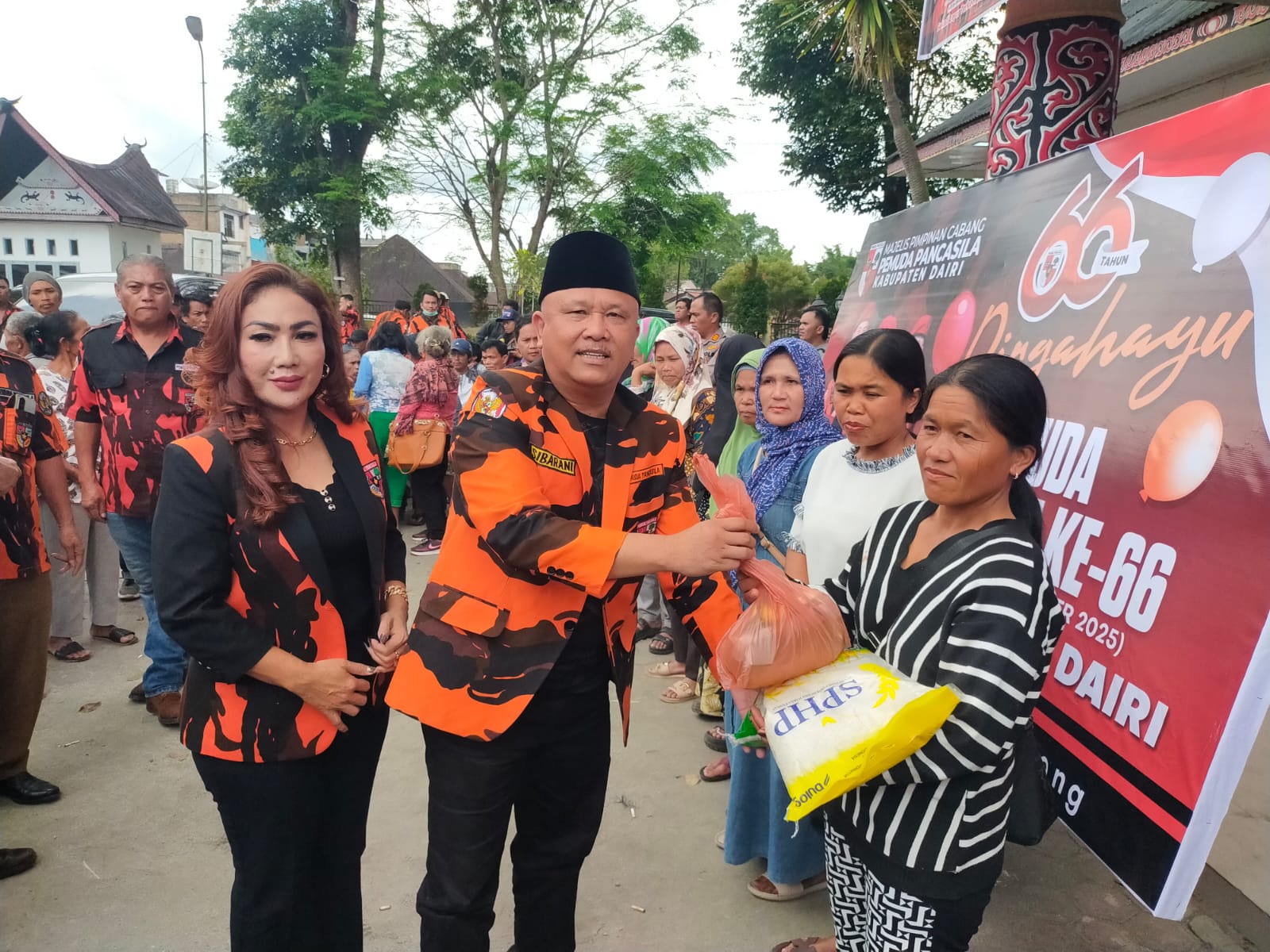 SERAHKAN. Ketua MPC PP Dairi, Sabam Sibarani S.Sos, MM didampingi istri, Lestina boru Sinaga serahkan bantuan sembako ke warga di gesung nasional Djauli Manik, Sidikalang, Senin (13/10/2025).