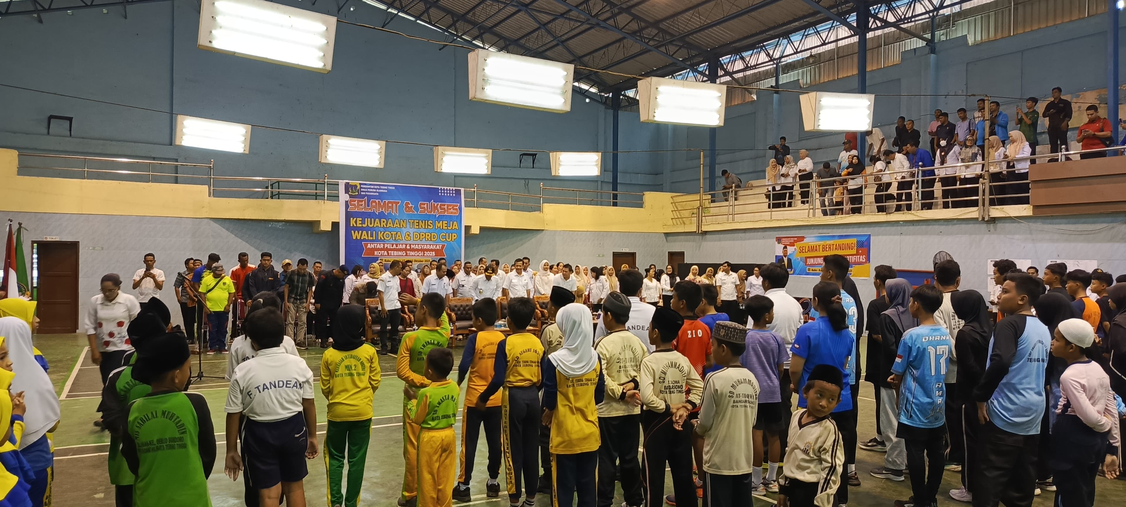 Wali Kota Tebing Tinggi, Iman Irdian Saragih, bersama para pejabat, ASN, dan masyarakat berdiri menyanyikan Lagu Indonesia Raya saat pembukaan Turnamen Tenis Meja di Gedung GOR Marahalim.