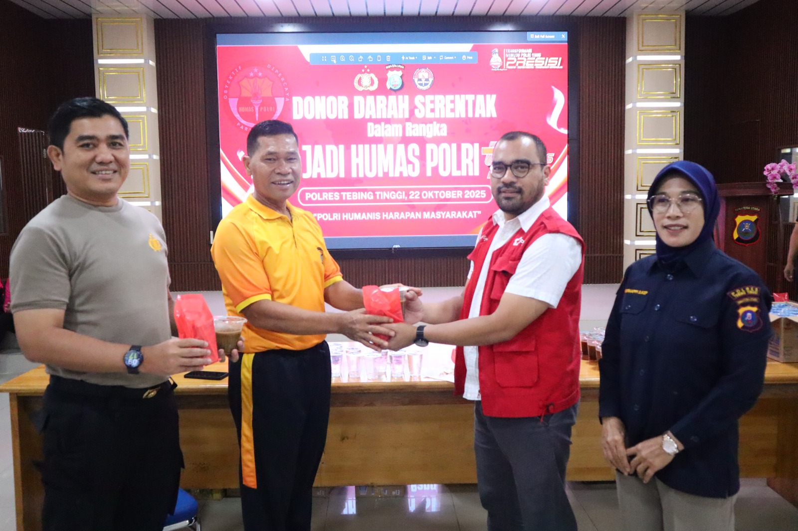 Kapolres Tebingtinggi AKBP Drs. Simon Paulus Sinulingga, S.H. menyerahkan cendera mata kepada perwakilan PMI Kota Tebingtinggi dr. Ade Syahputra Damanik usai donor darah. (AZAN PURBA/SUMUT POS)