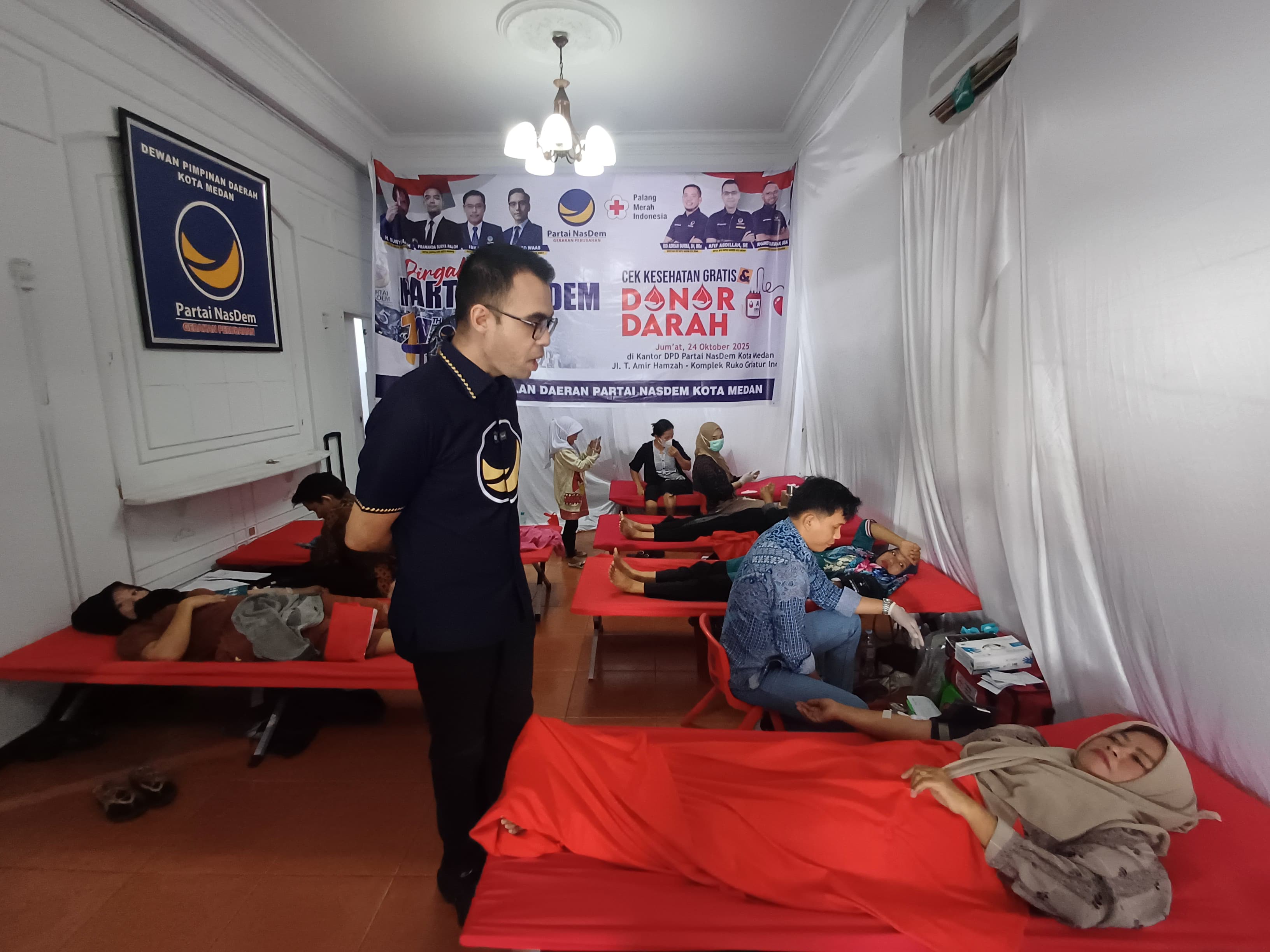 DONOR: Ketua DPD Partai NasDem Kota Medan, Afif Abdillah saat berbincang dengan pendonor darah pada kegiatan Donor Darah dan Cek Kesehatan Gratis, Jumat (24/10/2025). (Dok: Markus Pasaribu/Sumut Pos)