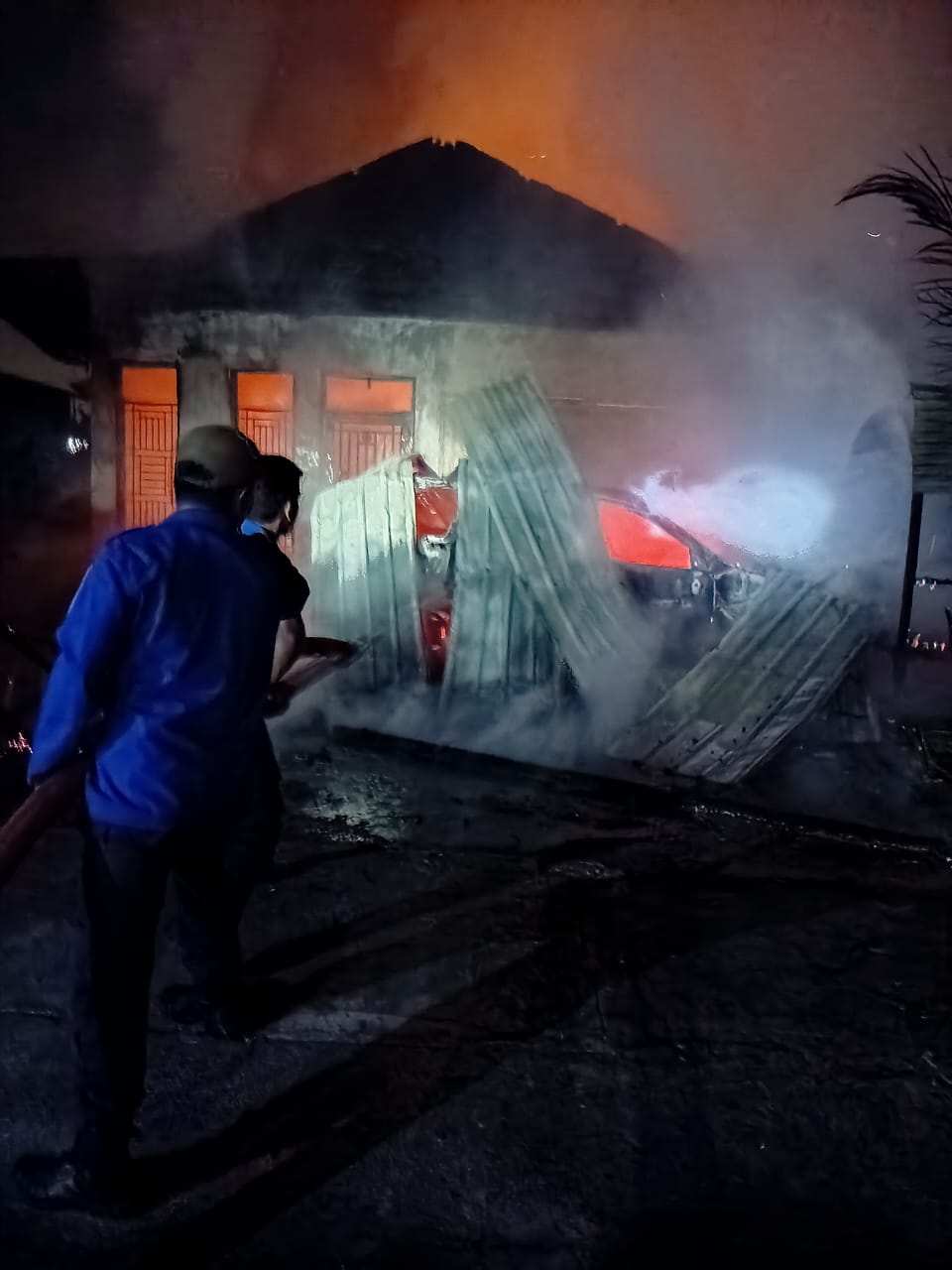 TERBAKAR: Warga dan petugas pemadam berusaha memadamkan api. (ISTIMEWA/SUMUT POS)