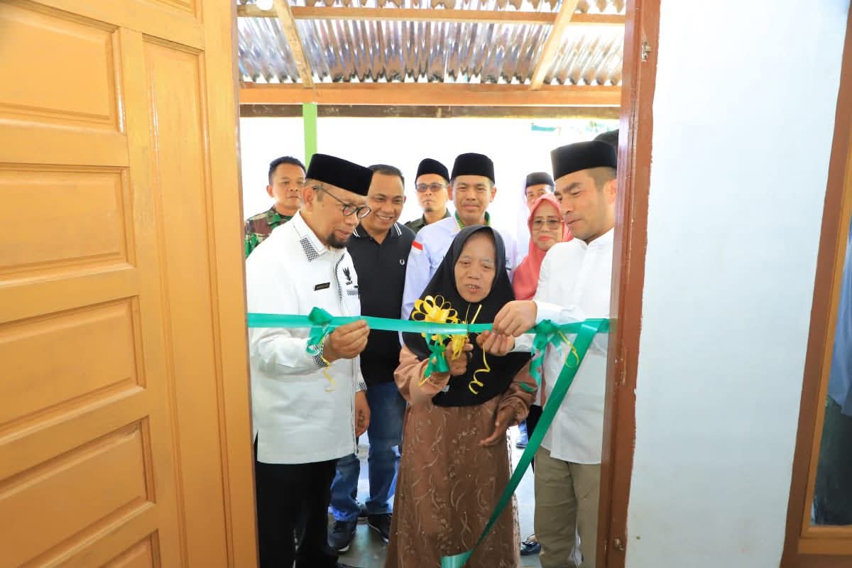 GUNTING PITA : Tanda rumah  telah diresmikan menjadi Rumah Layak Huni untuk diserahkan kepada pemiliknya. (Asri Tarigan/Sumut Pos)