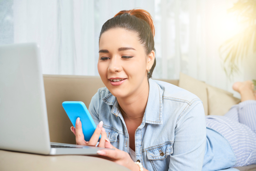 ILUSTRASI: Seorang wanita sedang asik  scrooling di laptop dan handphone.(FREEPIK)