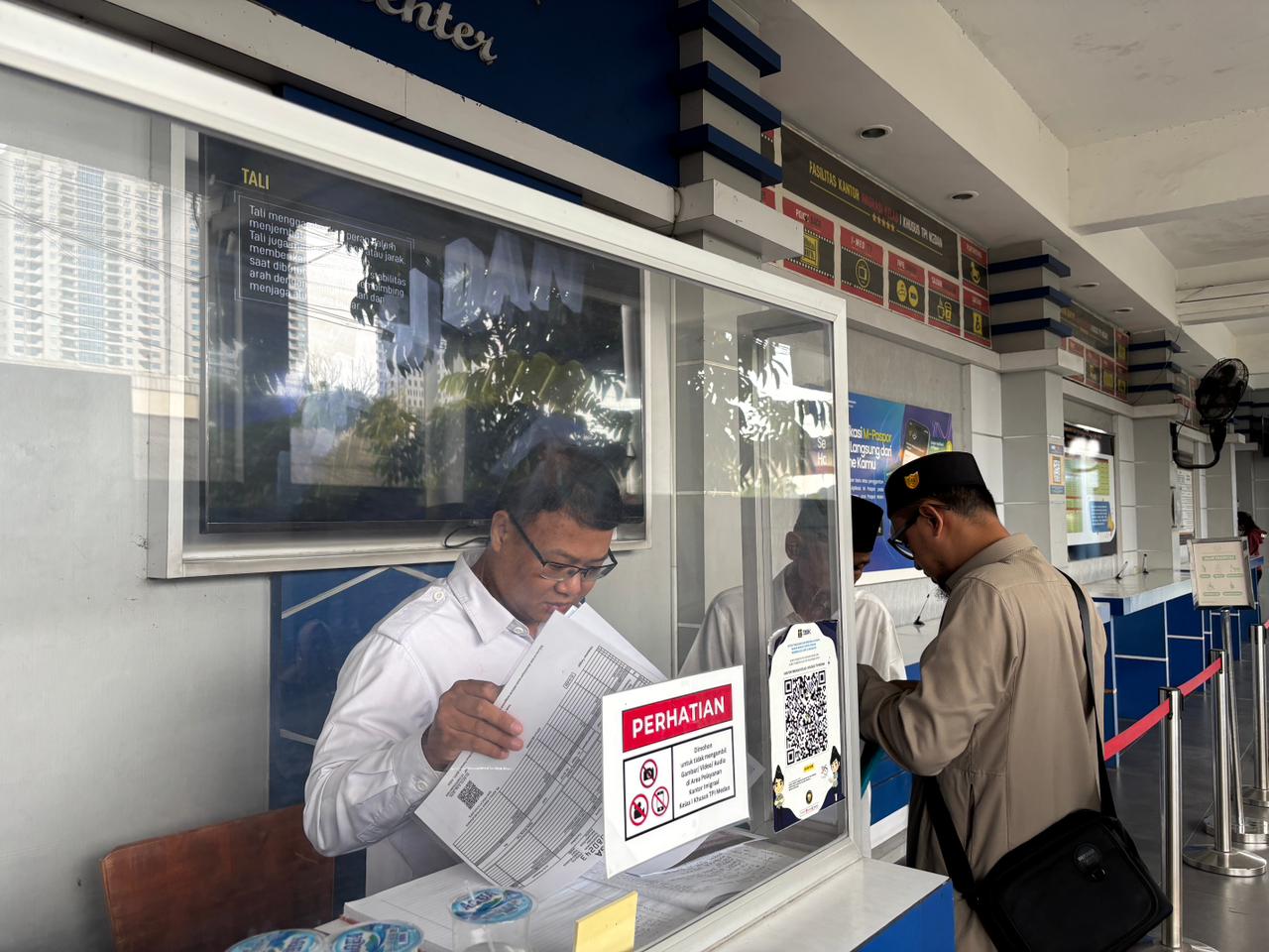 PERIKSA: Petugas Help Desk Imigrasi Medan saat memeriksa berkas warga yang akan mengurus paspor. (Dok: Imigrasi Medan)