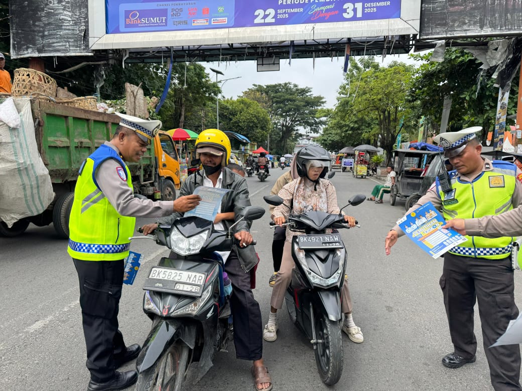 Petugas Sat Lantas Polres Tebing Tinggi membagikan brosur pemutihan pajak kendaraan dan memberikan imbauan tertib berlalu lintas kepada pengendara di Jalan Sutomo, Rabu (5/11/2025).