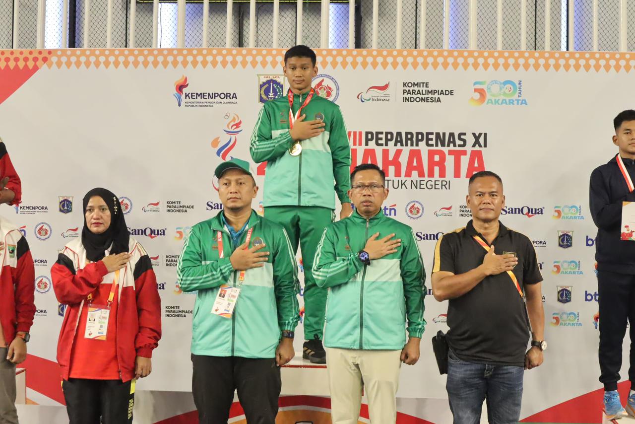 EMAS: Ketua Kontingen Sumatera Utara Maimun Masri bersama Rafael Samuel Siagian yang meraih medali emas wushu sanda kelas 70 kg putra di Popnas 2025. (Dok: Dispora Sumut)