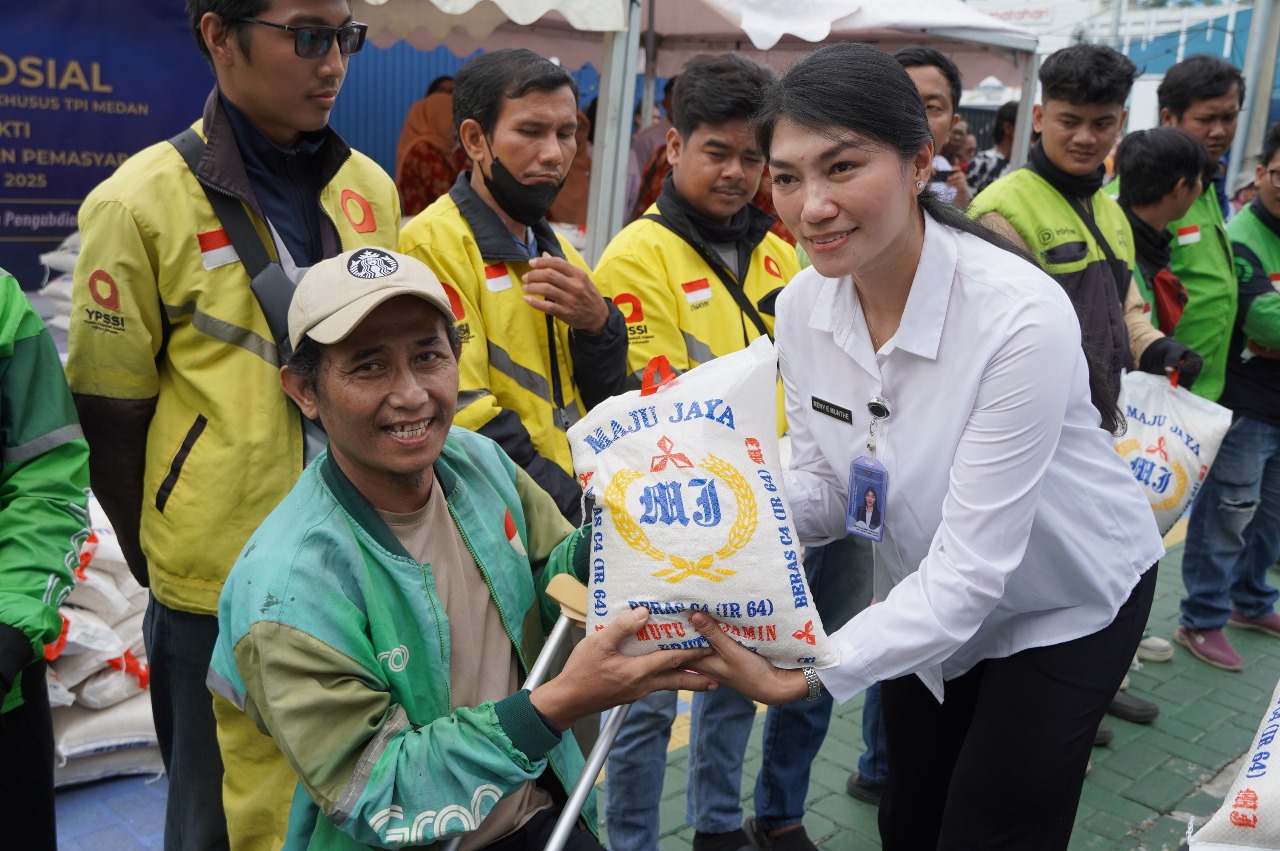 BERAS: Kepala Bidang Teknologi Informasi dan Komunikasi Keimigrasian, Reny Elisabeth Munthe saat memberikan beras kepada driver ojek online. (Dok: Juli Ramadhani Rambe/Sumut Pos)