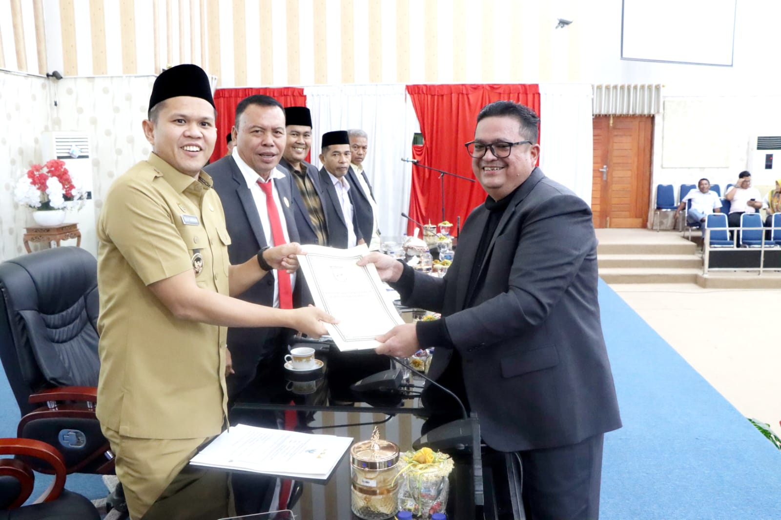 Wakil Bupati Sergai H. Adlin Tambunan menyerahkan dokumen Perda Pengelolaan Sampah kepada M. Akbar Dev ST usai rapat paripurna di Gedung DPRD Sergai, Seirampah.(FADLY/SUMUT POS)