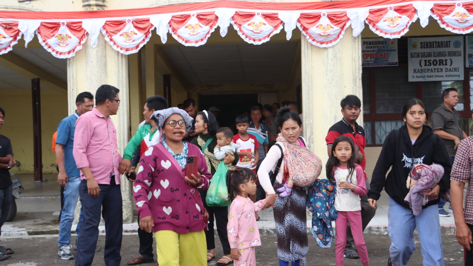 PULANG: Puluhan warga Desa Parbuluan 6, Kecamatan Parbuluan, Kabupaten Dairi, yang sempat mengungsi ke Mapolres Dairi dan GOR Sidikalang pulang, Jumat (14/11/2025).