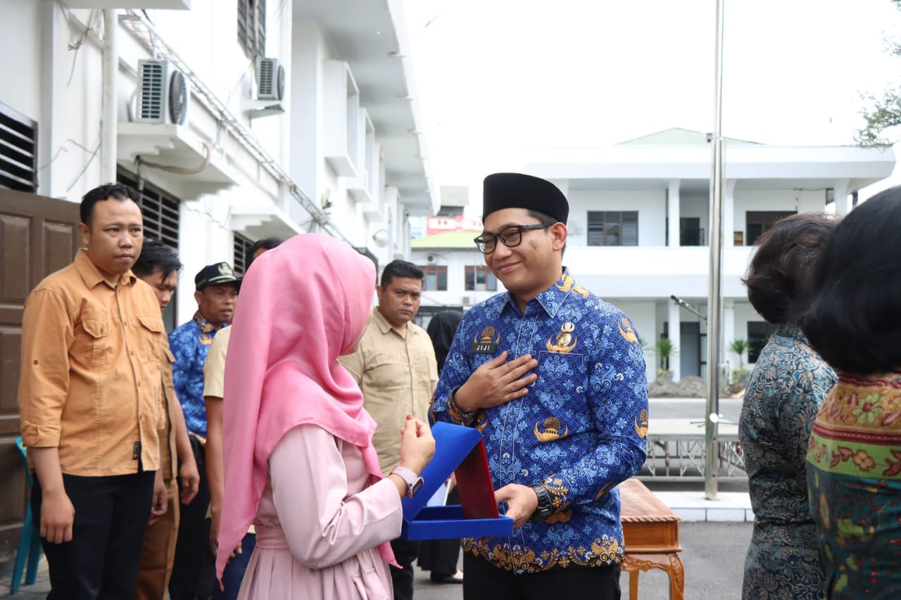 Wawako Binjai, Hasanul Jihadi saat memberikan cinderamata kepada Anggota Korpri yang purna tugas. (Diskominfo Binjai/Sumut Pos)