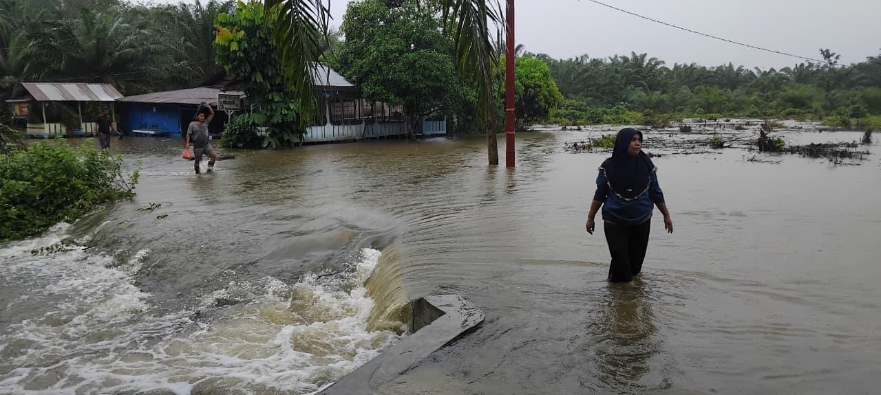 BANJIR: Warga saat melintasi jalan yang banjir di Kabupaten Tapanuli Selatan. (Dok: istimewa)