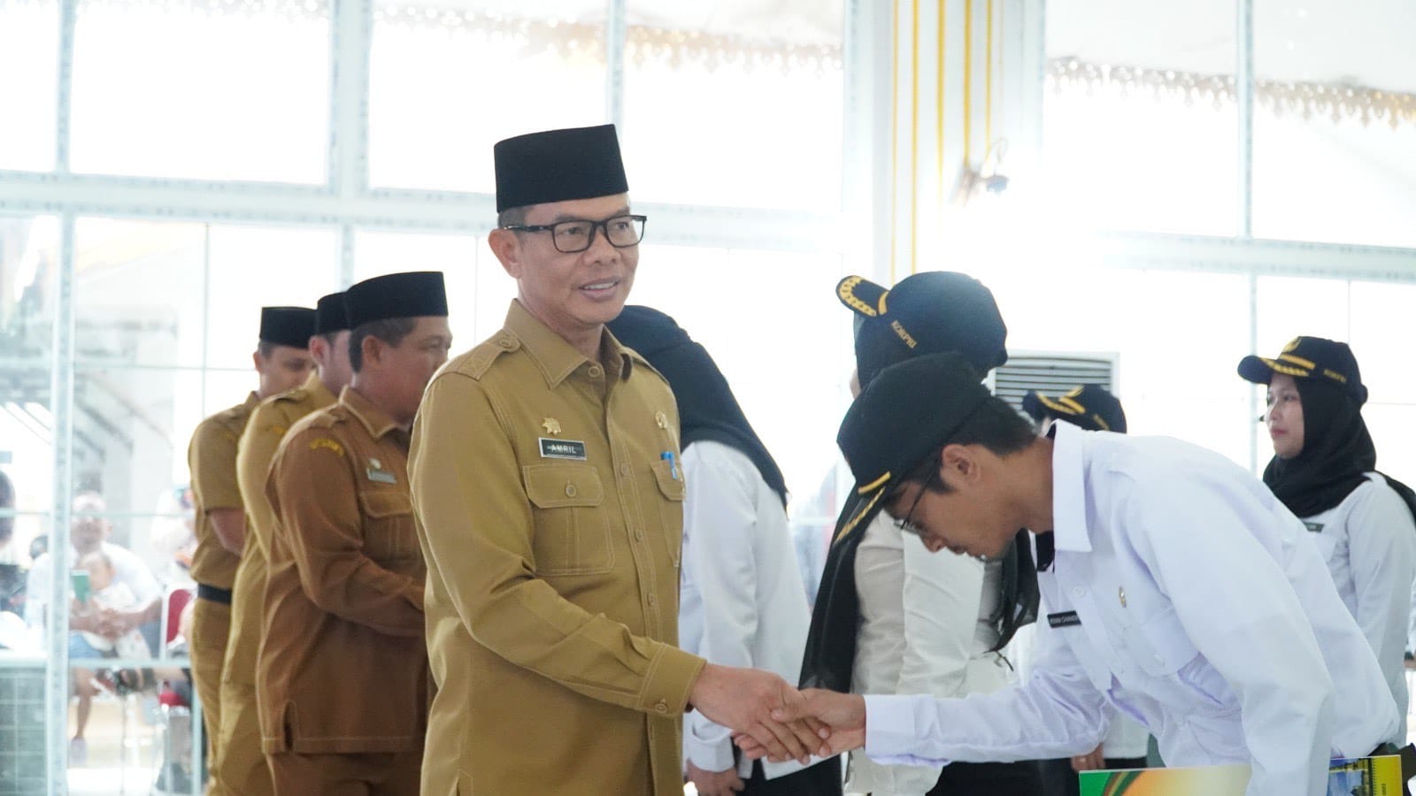 Sekda Langkat, Amril menyalami PPPK tahap II TA 2024 yang dilantik di Jentera Malay, Stabat. (Diskominfo Langkat/Sumut Pos)