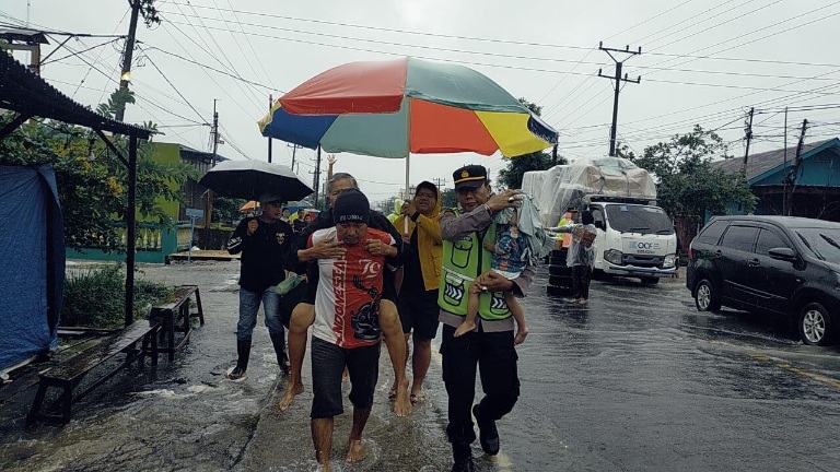 BENCANA: Personel Kepolisian jajaran Polda Sumut saat membantu korban bencana. (Dok: istimewa)
