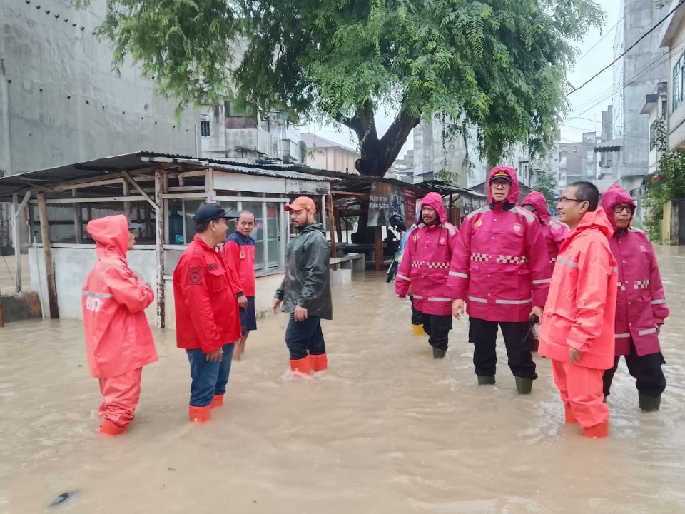 TINJAU: AKP Herliandri bersama kepala BPBD Tebingtinggi, Chairun Nasrin Nasution meninjau kondisi banjir sekaligus evakuasi warga di lokasi terdampak, Kamis (27/11/2025). (Dok: Azan Purba/Sumut Pos)