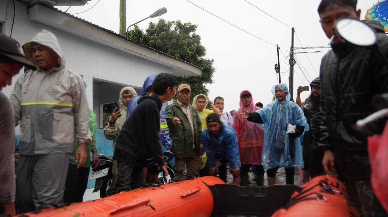 Wakil Bupati Deliserdang Lom Lom Suwondo ikut membantu petugas  BPBD mengevakuasi warga yang terdampak banjir. (BATARA/SUMUT POS)