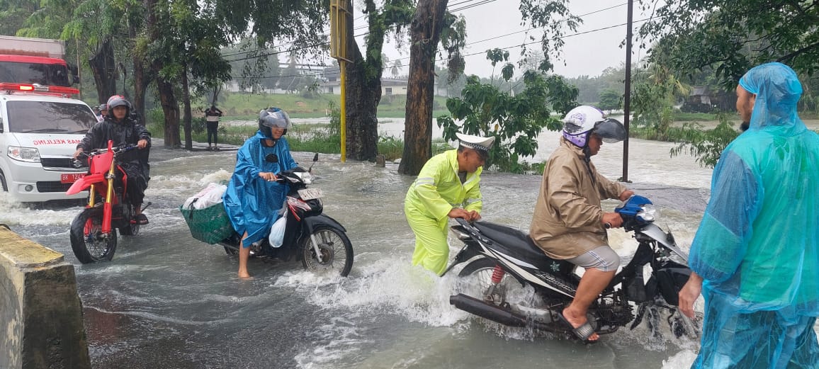 Personil Polresta Deliserdang memberikan bantuan kepada warga yang terjebak banjir. (BATARA/SUMUT POS)