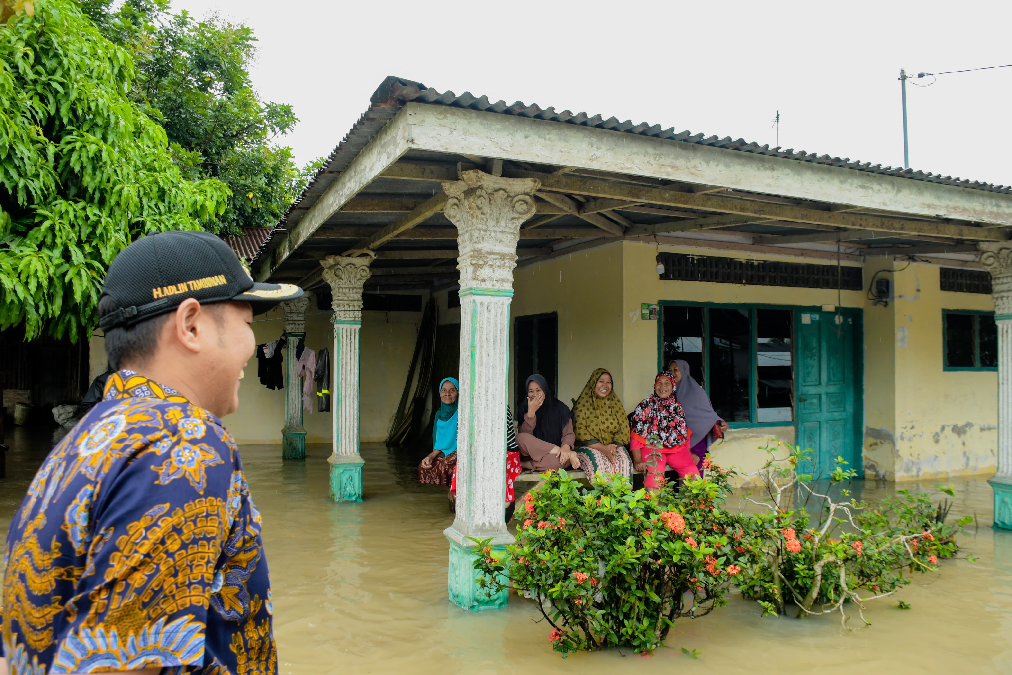 Wakil Bupati Serdang Bedagai Adlin Tambunan  meninjau permukiman warga yang terdampak banjir. Sejumlah warga terlihat duduk di teras rumah mereka yang tergenang air. ( Fadly/Sumut Pos )