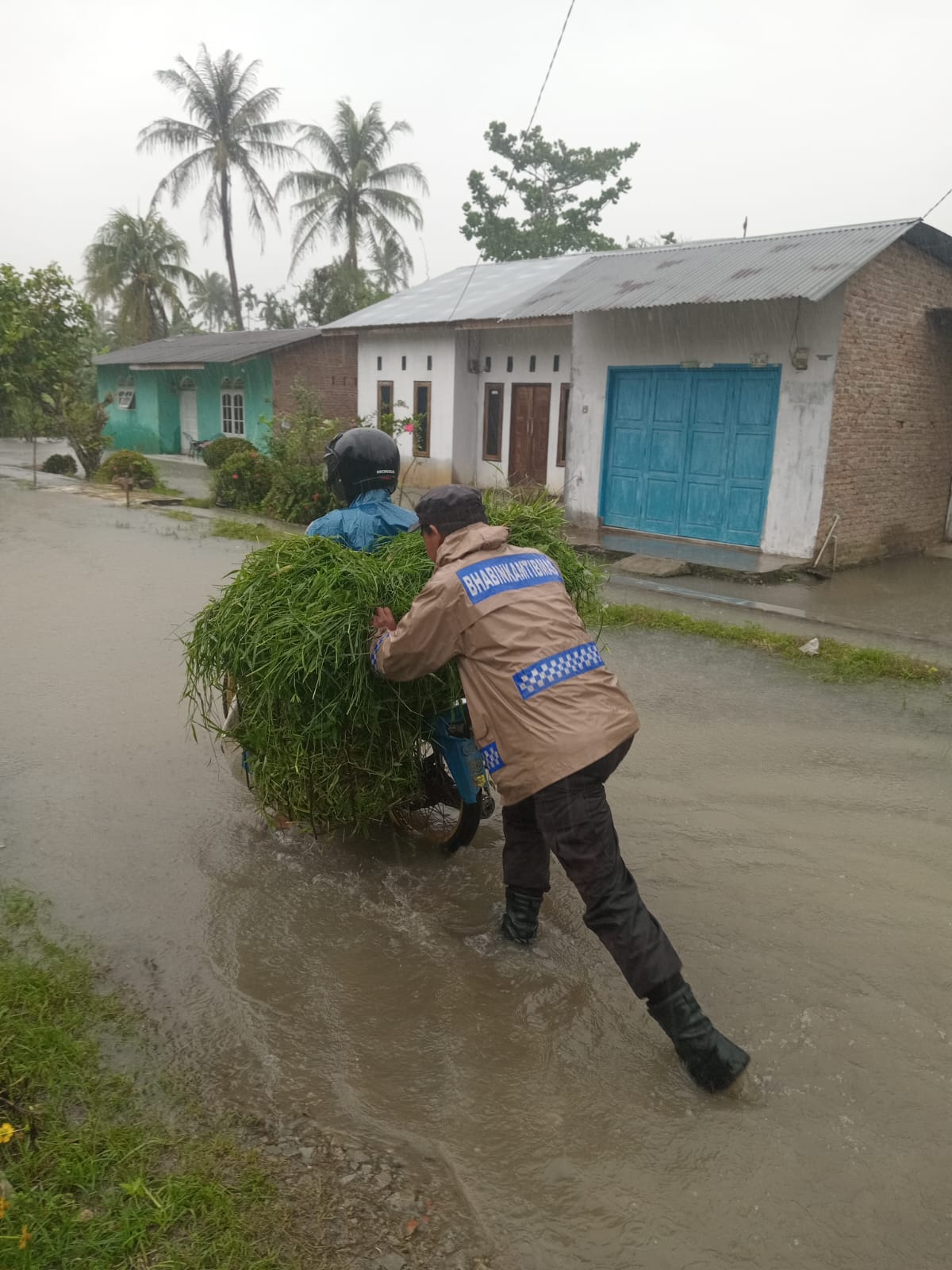 Salah satu personil polres Sergai saat bantu korban terjebak banjir. ( Fadly/ Sumut Pos )
