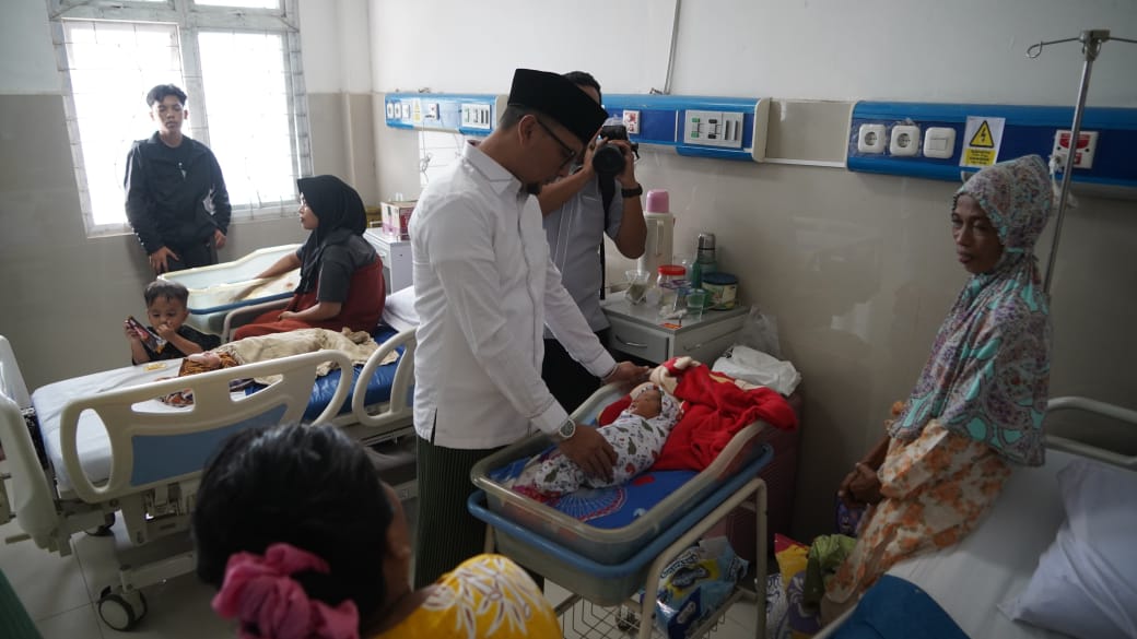 Bupati Labusel, Fery Sahputra Simatupang,  menemui Fitri Kusuma Harahap, pasien pasca operasi caesar di RSUD Kotapinang. (KHAIRUDDIN/SUMUT POS)