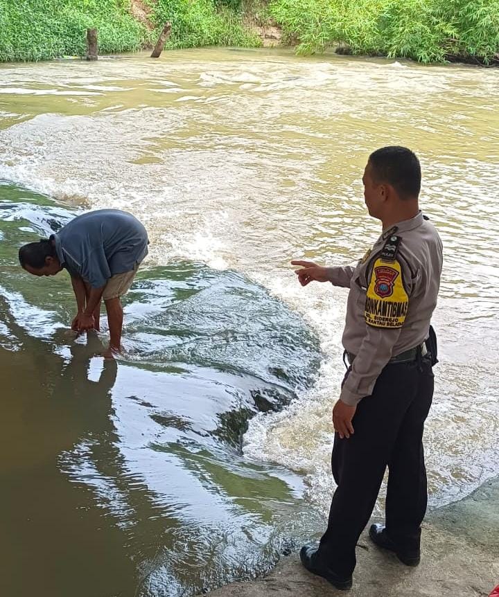 DEBIT: Bhabinkamtibmas Kelurahan Sidorejo, Aiptu J Samosir saat pengecekan debit air Sungai Aek Kundur di Lingkungan Bulu Cina, Kecamatan Rantau Selatan (Dok: Fajar/Sumut Pos)