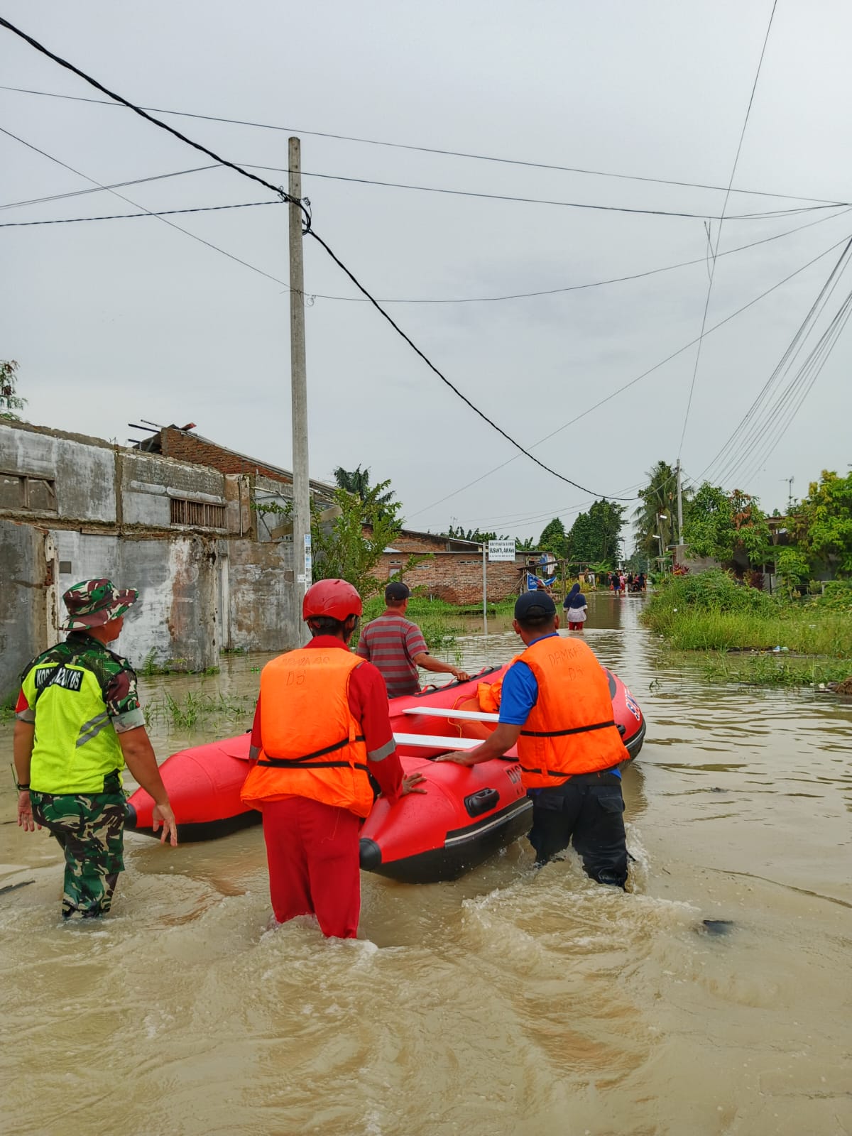 EVAKUASI: Tim SAR dibantu oleh warga melakukan evakuasi kepada warga yang terjebak di rumah mereka karena genangan air yang tinggi. (Dok: istimewa)