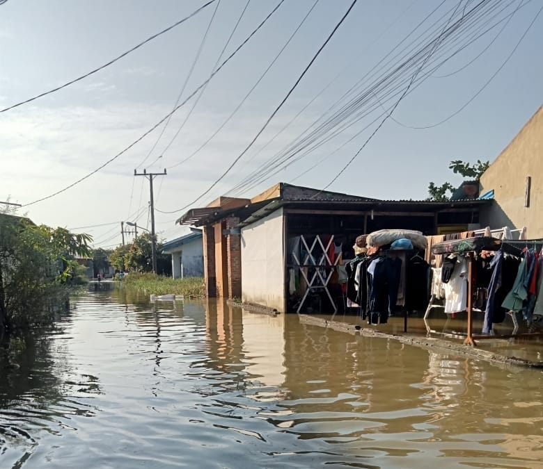 TERISOLIR: Warga di Komplek TKBM, Kelurahan Sei Mati, Kecamatan Medan Labuhan, Kota Medan, terisolir akibat banjir yang telah mengepung kawasan mereka selama tiga hari, hingga Senin (1/12/2025).