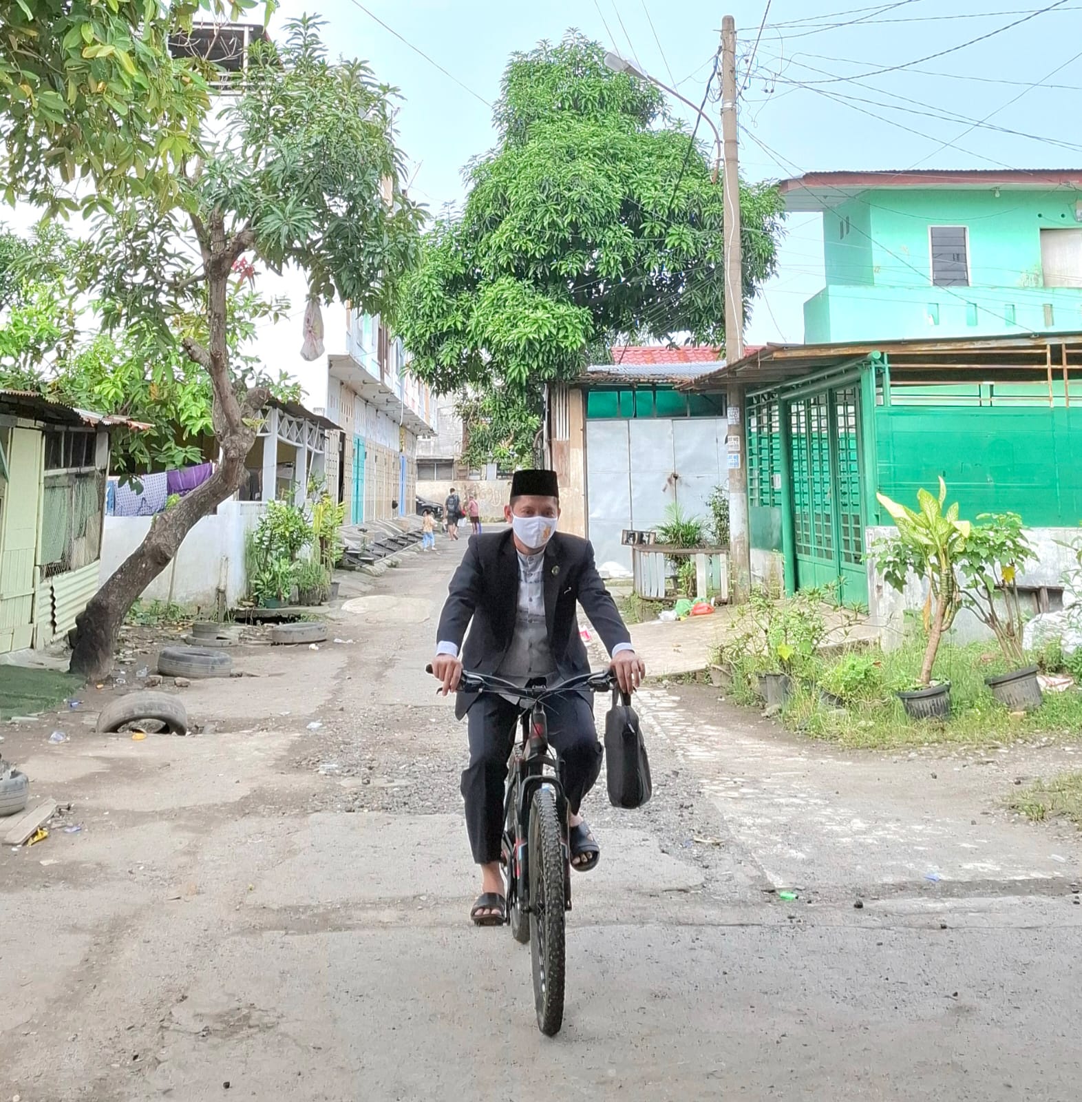 BBM Langka: H. Ramlan, mengendarai sepeda saat menuju lokasi tugas menikahkan pengantin karena motornya tidak ada BBM. (Dok: istimewa)