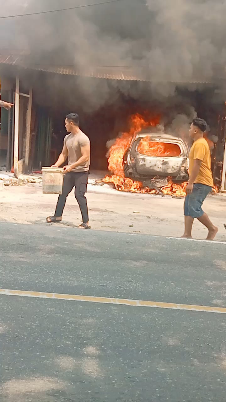 Warga berusaha memadamkan mobil yang terbakar di depan Kantor DPRD Sergai. (FADLY/SUMUT POS)