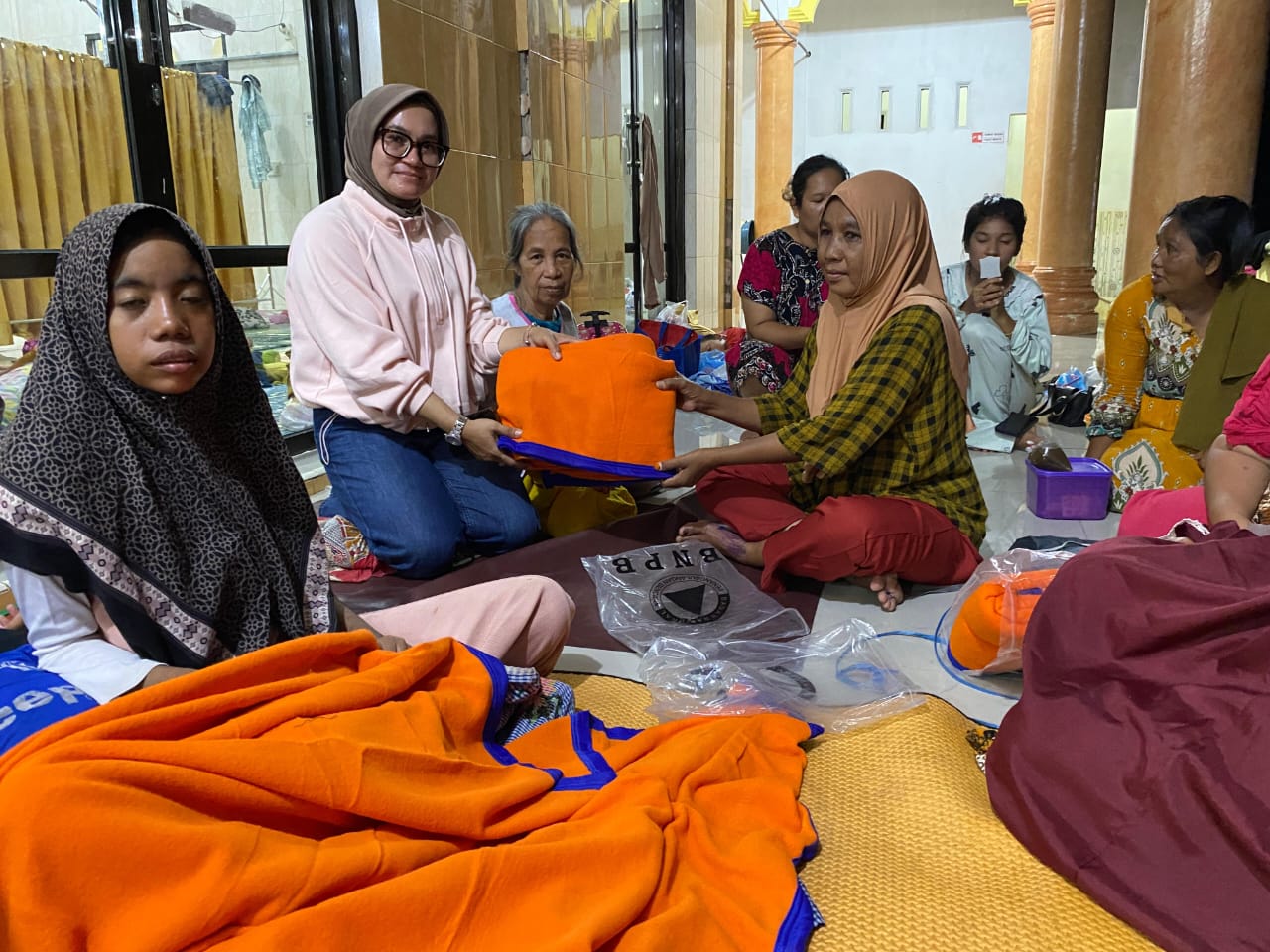 Camat Tanjung Beringin Nurchinta Devi Tambunan saat membagikan selimut dan perlengkapan bayi kepada warga terdampak banjir di lokasi pengungsian. (Fadly/Sumut Pos)