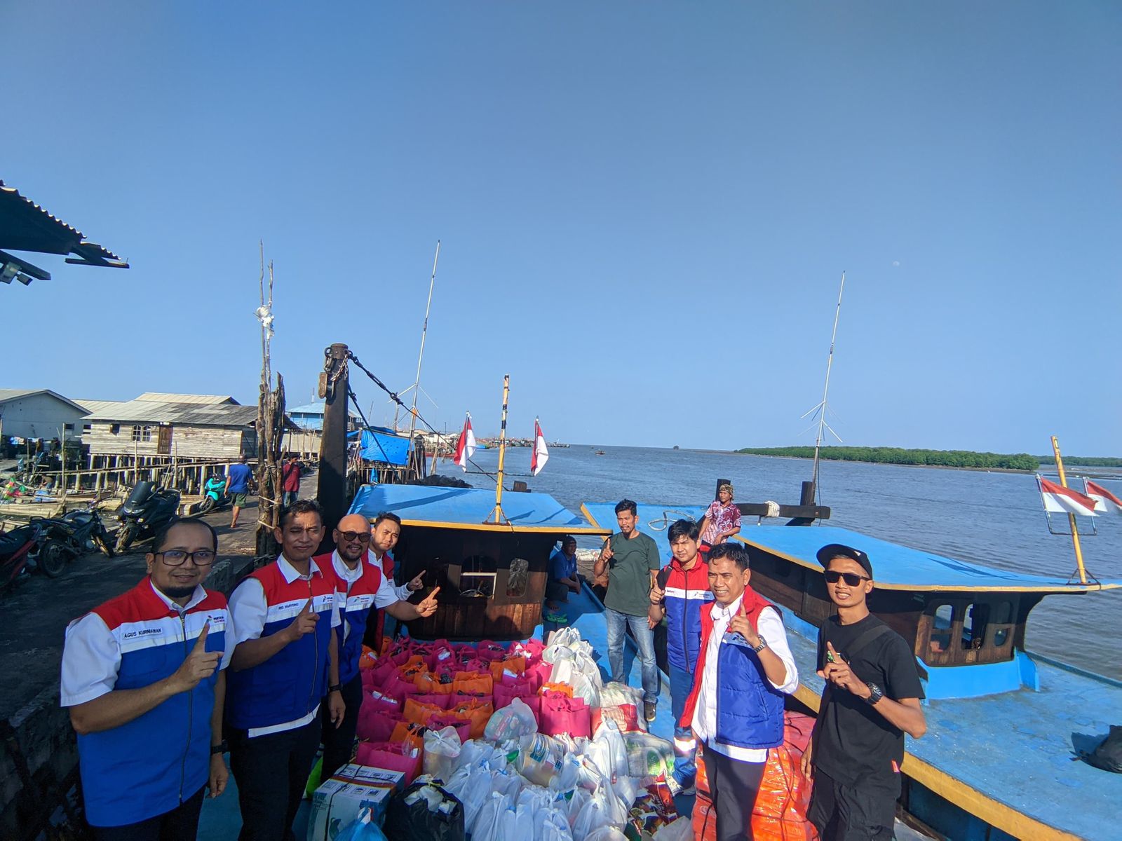 BANTUAN: Karyawan PGN saat menyerahkan bantuan kepada warga terdampak banjir dan laut di Langsa. Distribusi melalui laut. (Dok: PGN)